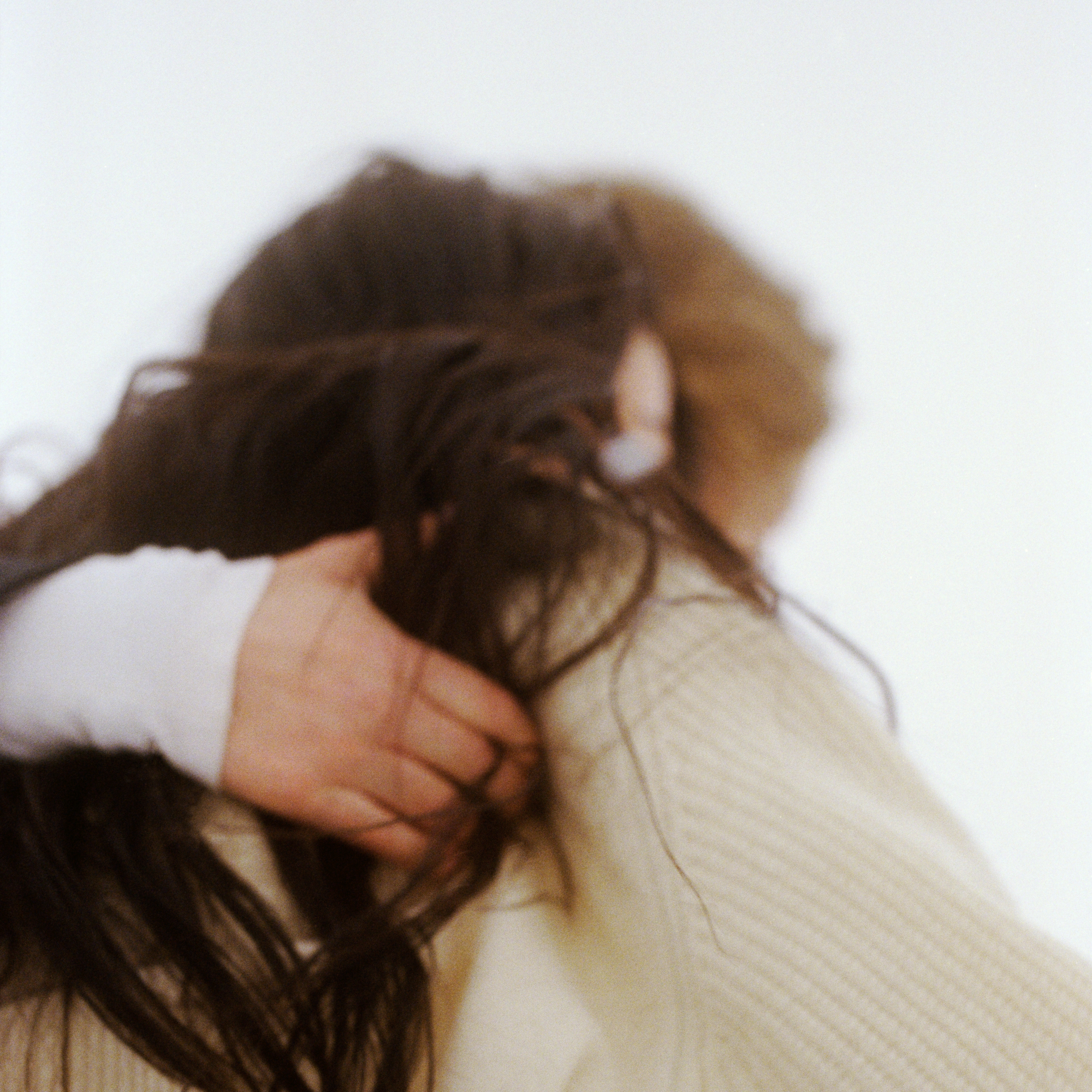 Two people with long hair holding eachother